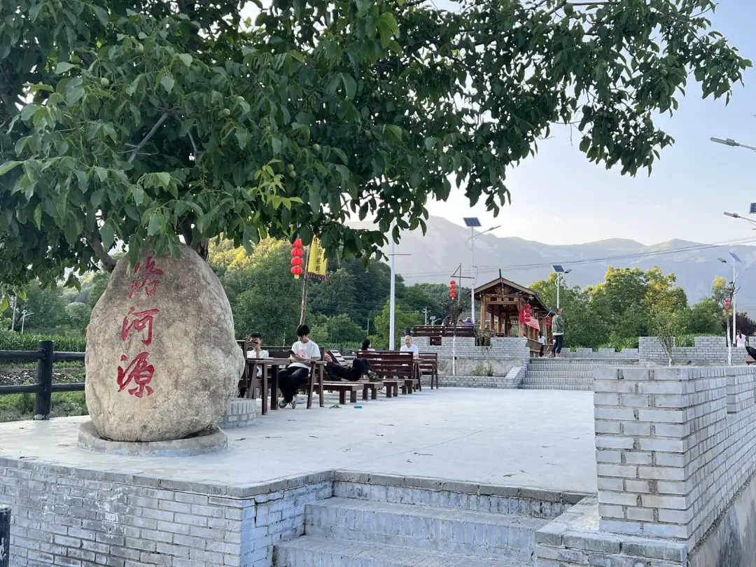 游客在洛源镇桃坪村河边的休闲长廊休憩。